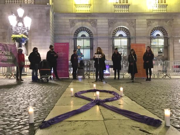 Imatge on es veu un llaç lila i les dones participants a la concentració 