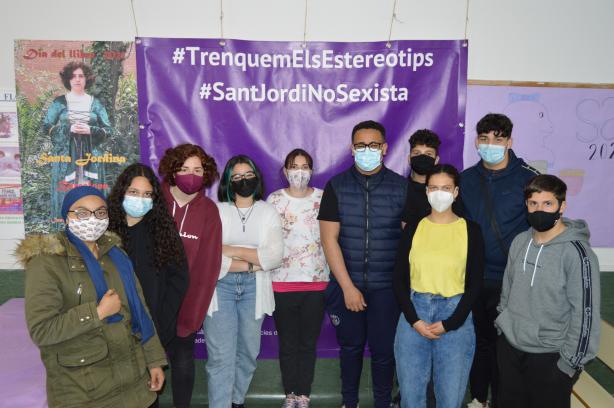Alumnes d'un institut davant una pancarta amb els lemes "Trenquem els estereotips" i "Sant Jordi no sexista"
