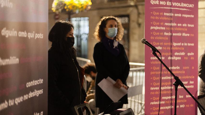 Cartells on s'indica què és violència i què no és violència de fons, una dona fent un parlament