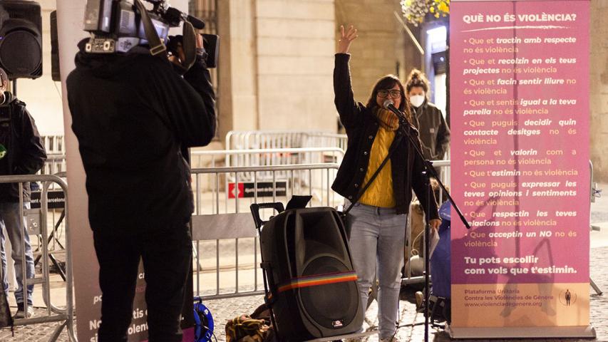 artells on s'indica què és violència i què no és violència de fons, una dona fent un parlament amb el braç aixecaat